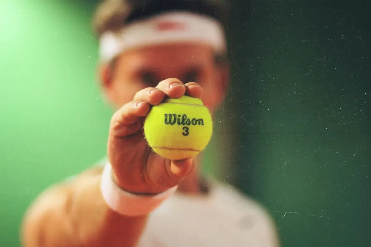 man met tennisbal vast