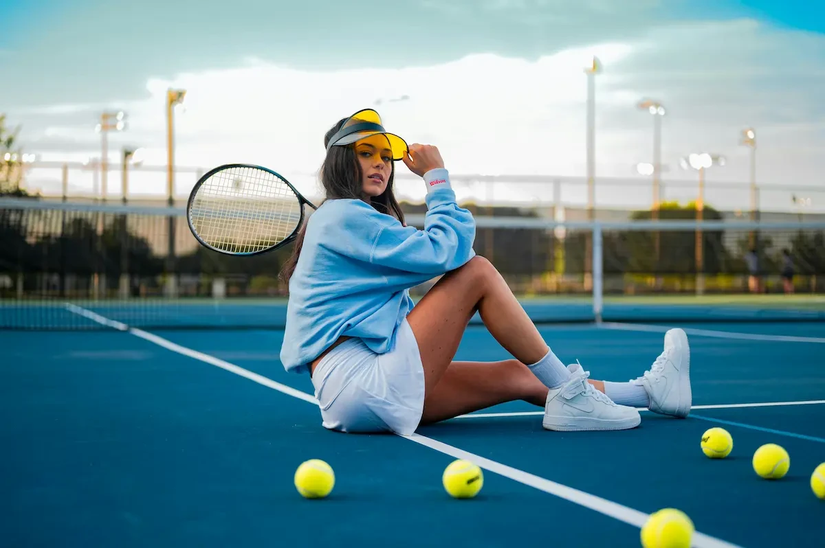 vrouw met pet op tennisveld